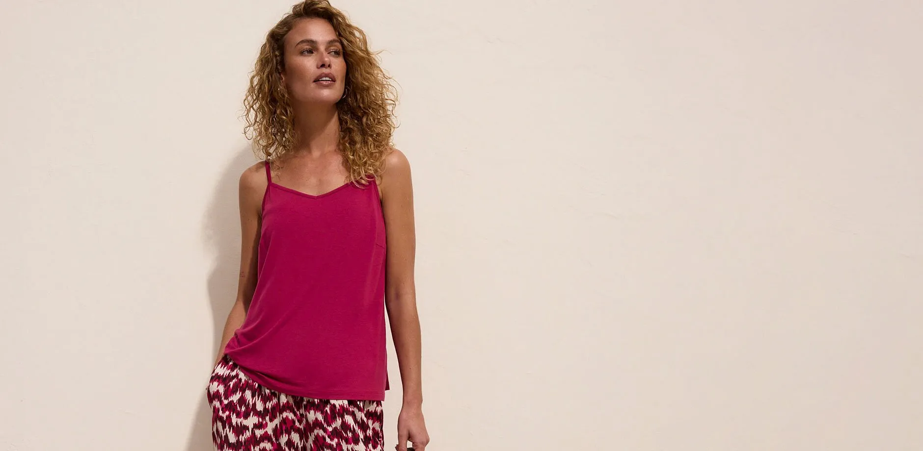 Un top rosa con spalline e un paio di pantaloni con una fantasia vivace.