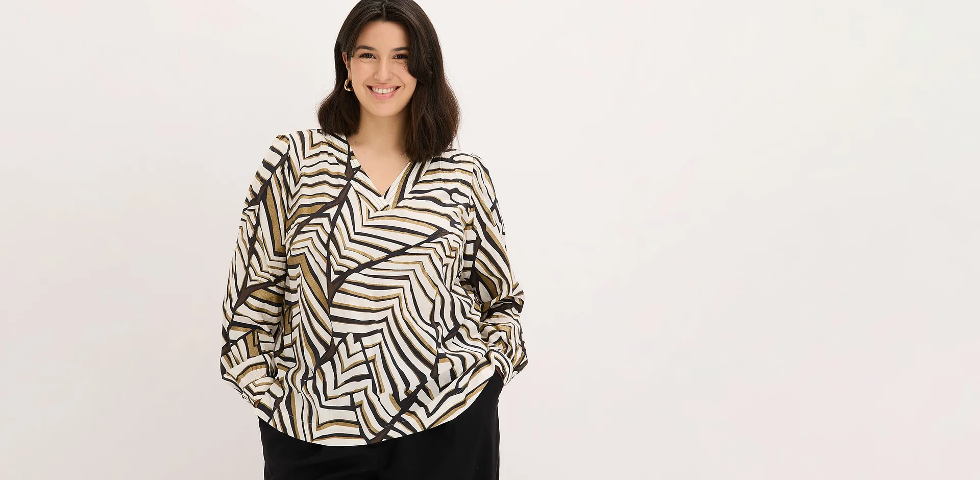 Blusa con motivo grafico e pantaloni neri.