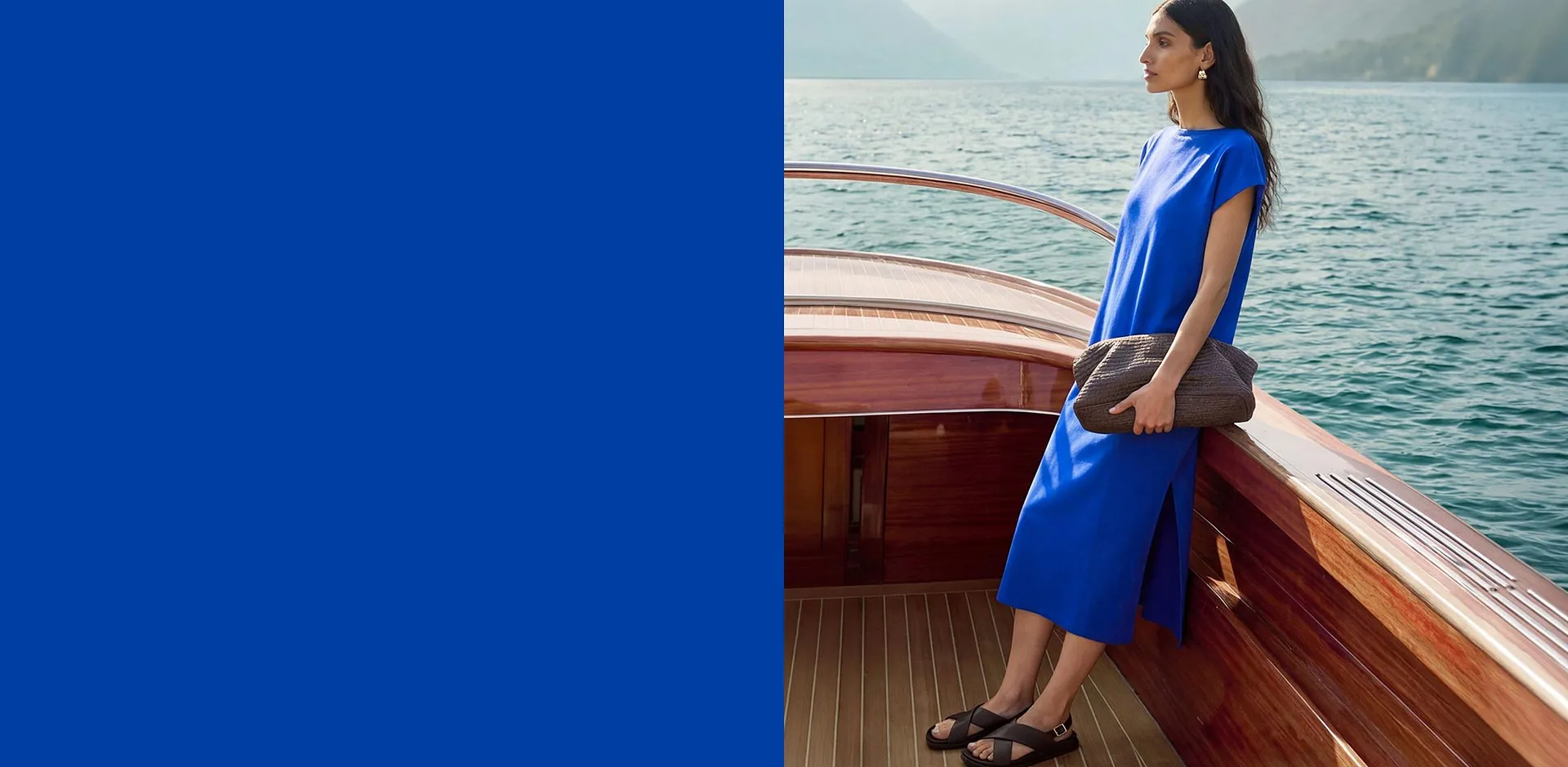 Un abito midi blu brillante, comodi sandali e un'elegante borsa con texture.