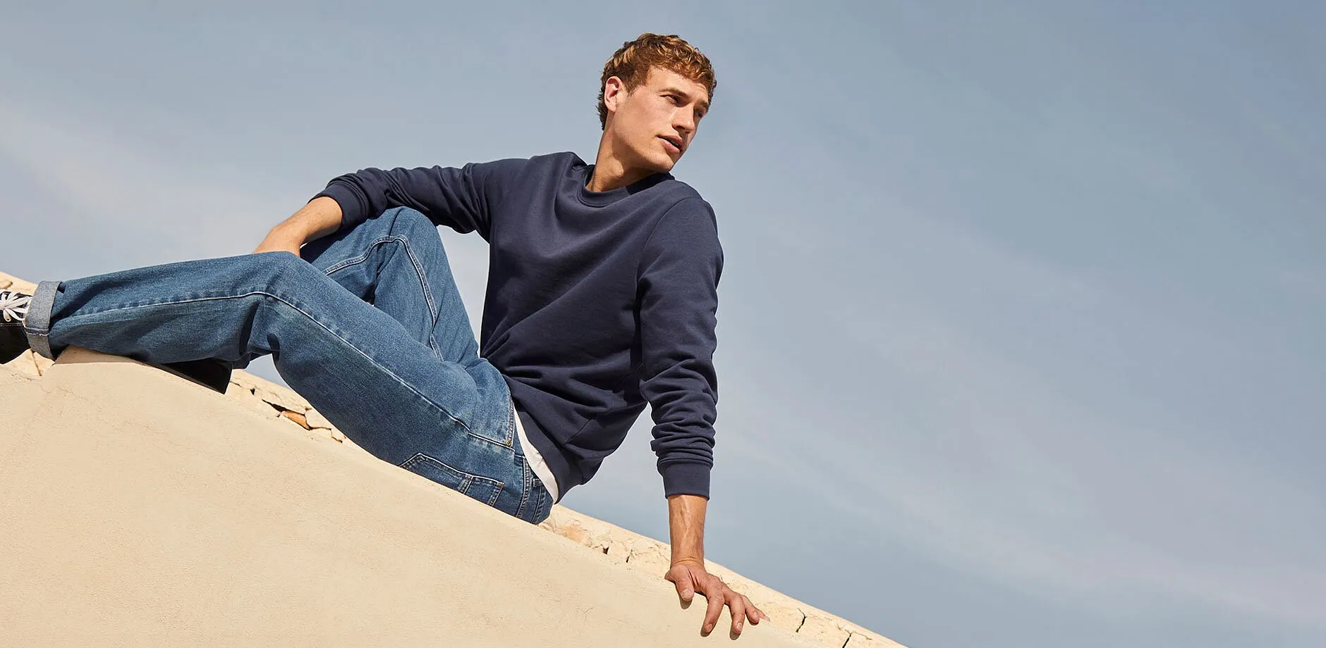 Una semplice felpa blu, dei jeans classici e delle scarpe da ginnastica.