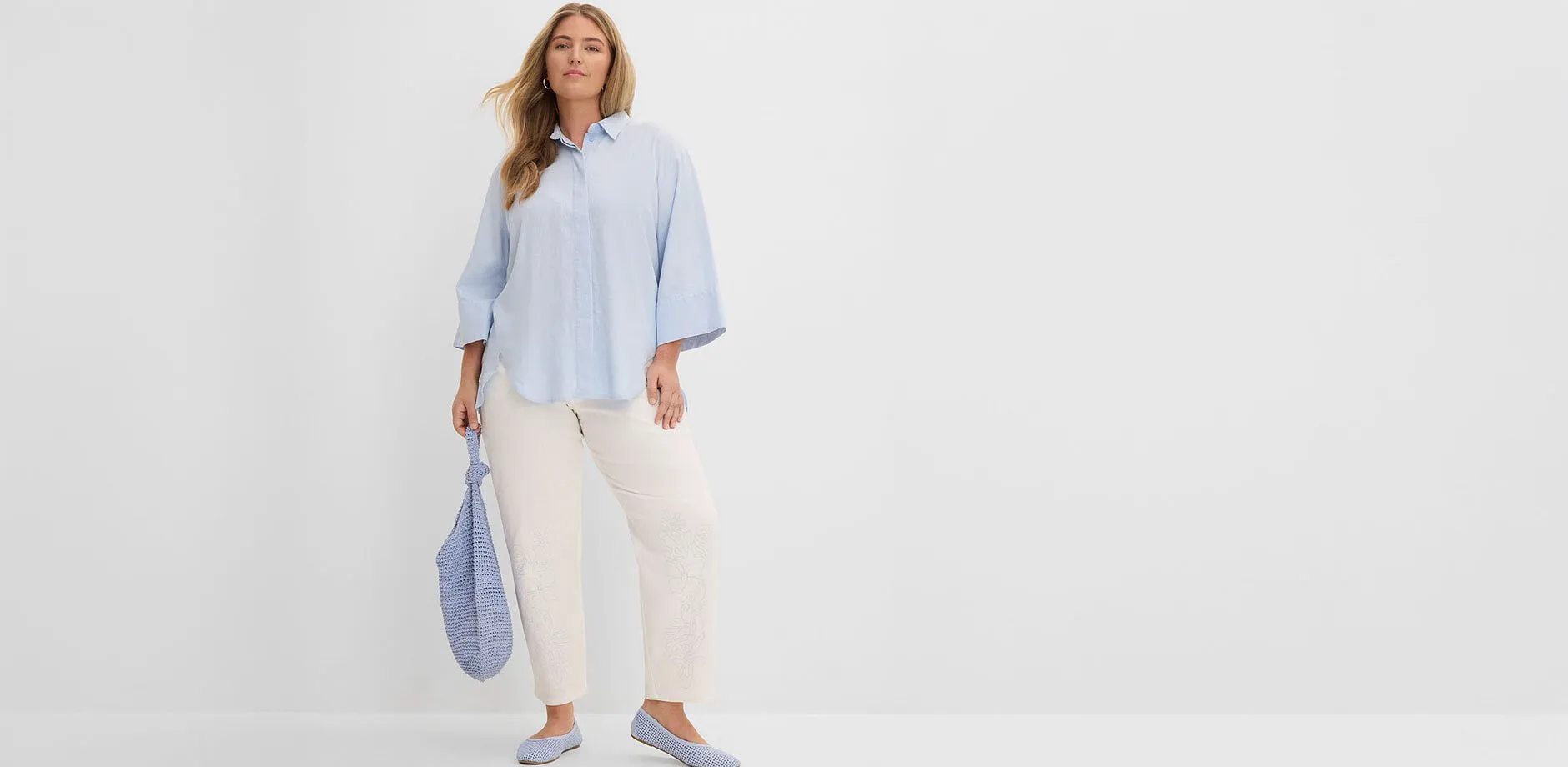 Camicia azzurra, pantaloni chiari, ballerine e borsa abbinate.