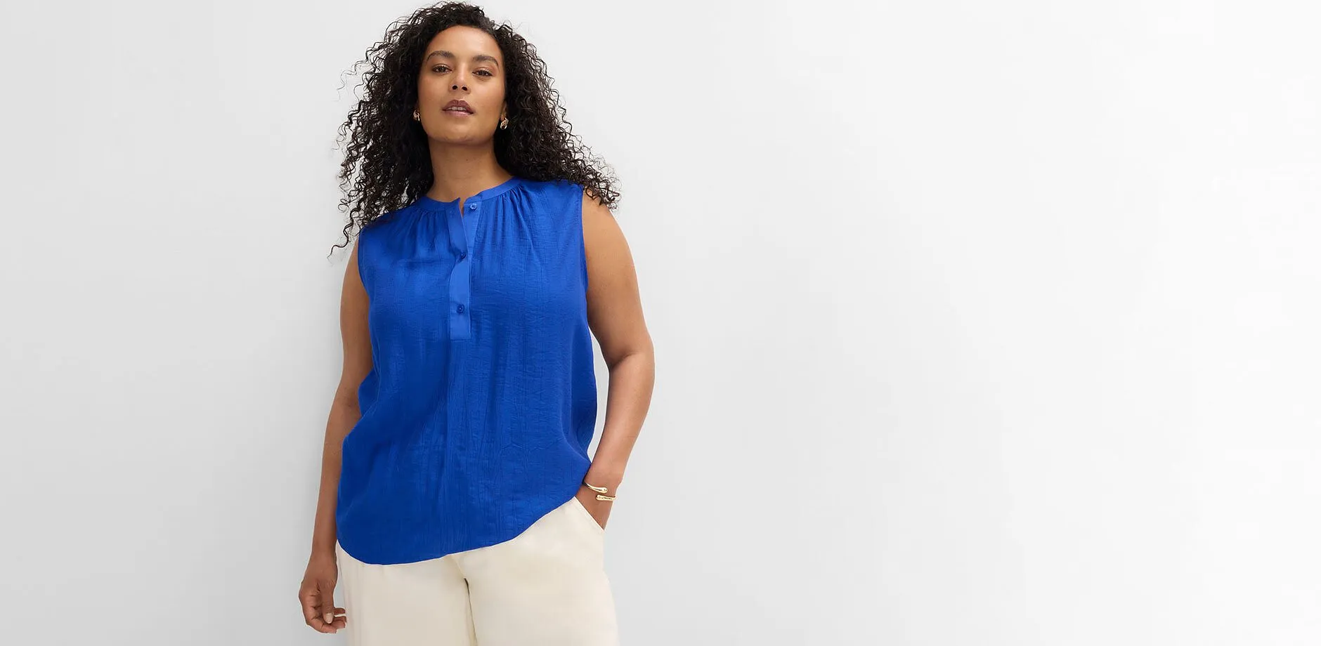 Un top stile camicetta in un brillante blu reale e un paio di pantaloni chiari e casual.