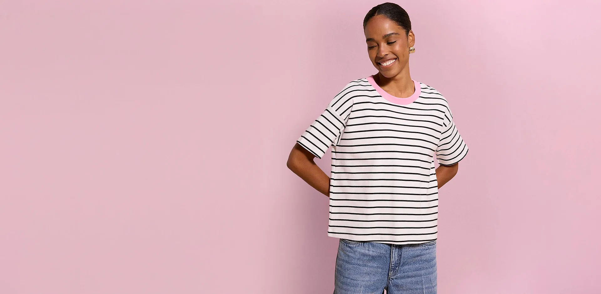 T-shirt casual a righe con colletto rosa e jeans blu.