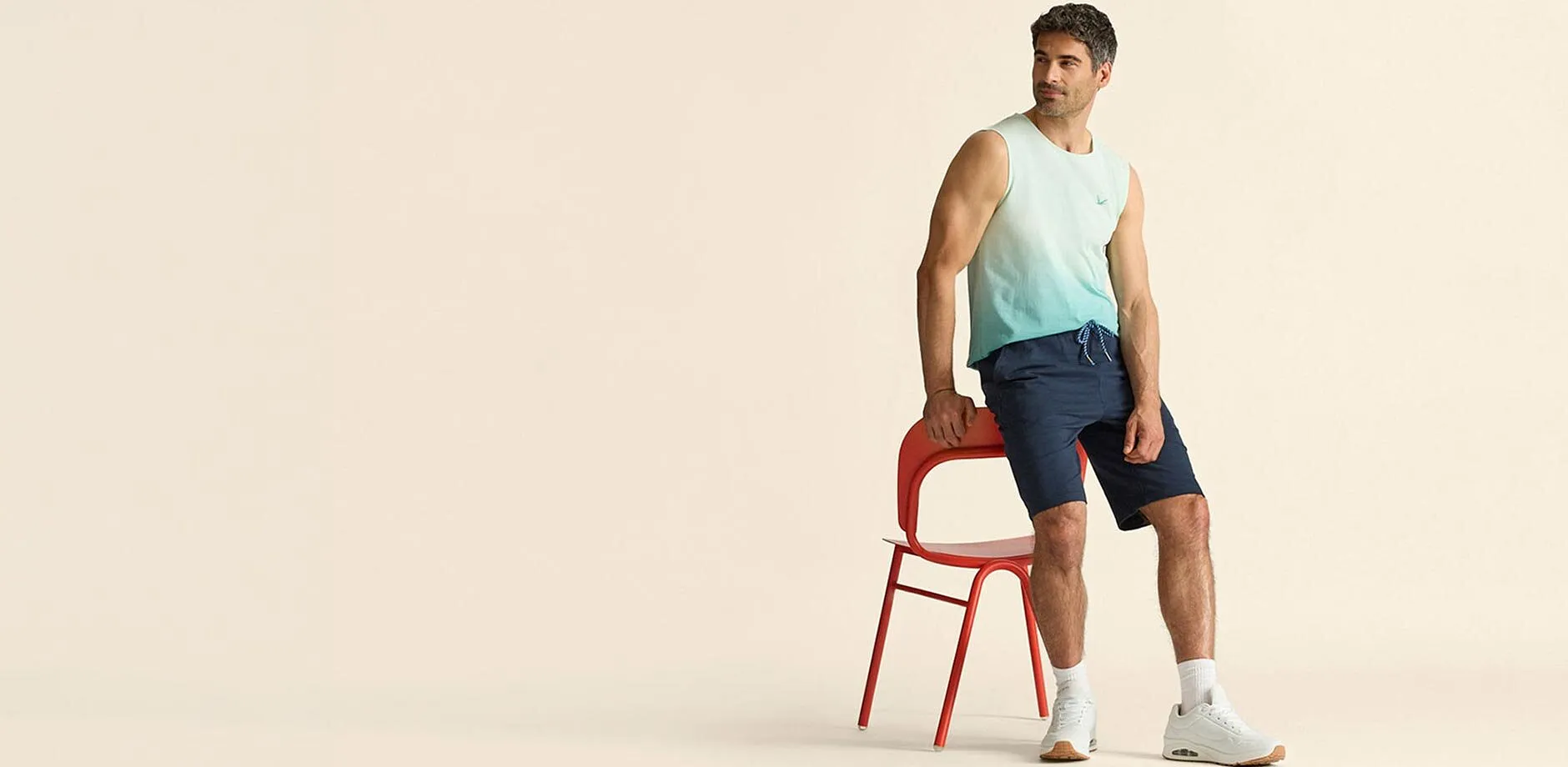 Canotta trendy dai colori sfumati, abbinata a pantaloncini blu e sneaker bianche.