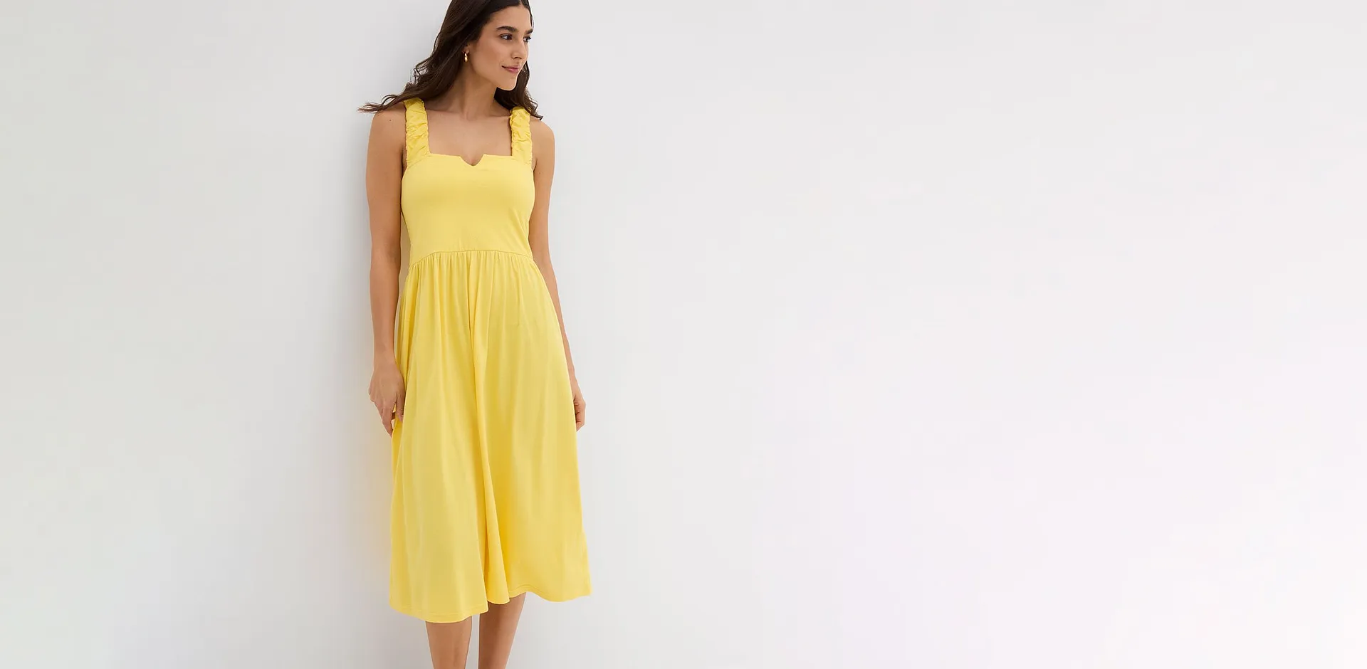 Un abito midi giallo che non passa inosservato, con spalline raffinate e una vestibilit&agrave; comoda.