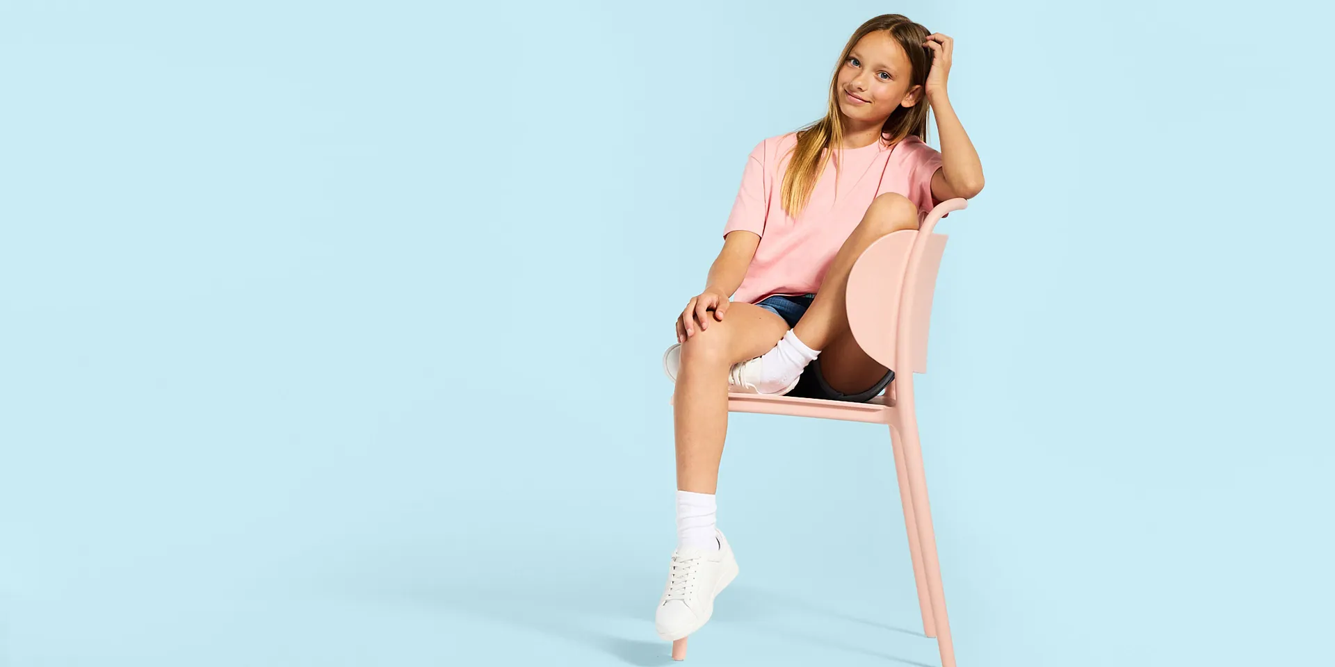 T-Shirt rosa, jeans corti, calzini bianchi e scarpe da ginnastica.