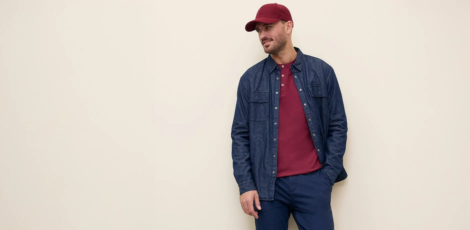 Camicia di jeans sopra una maglietta, pantaloni scuri.