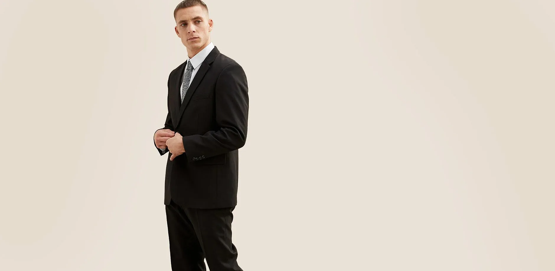 Elegante completo nero con camicia bianca e cravatta.