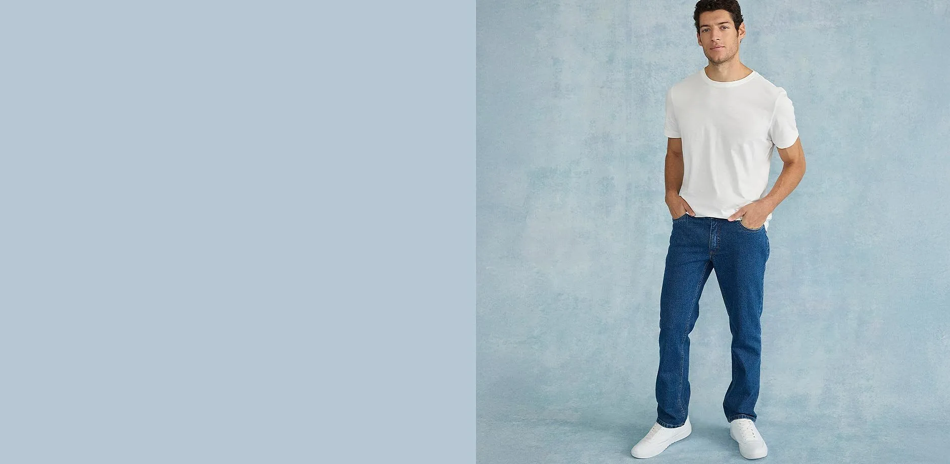 Maglietta bianca, jeans blu regular fit e scarpe da ginnastica bianche.