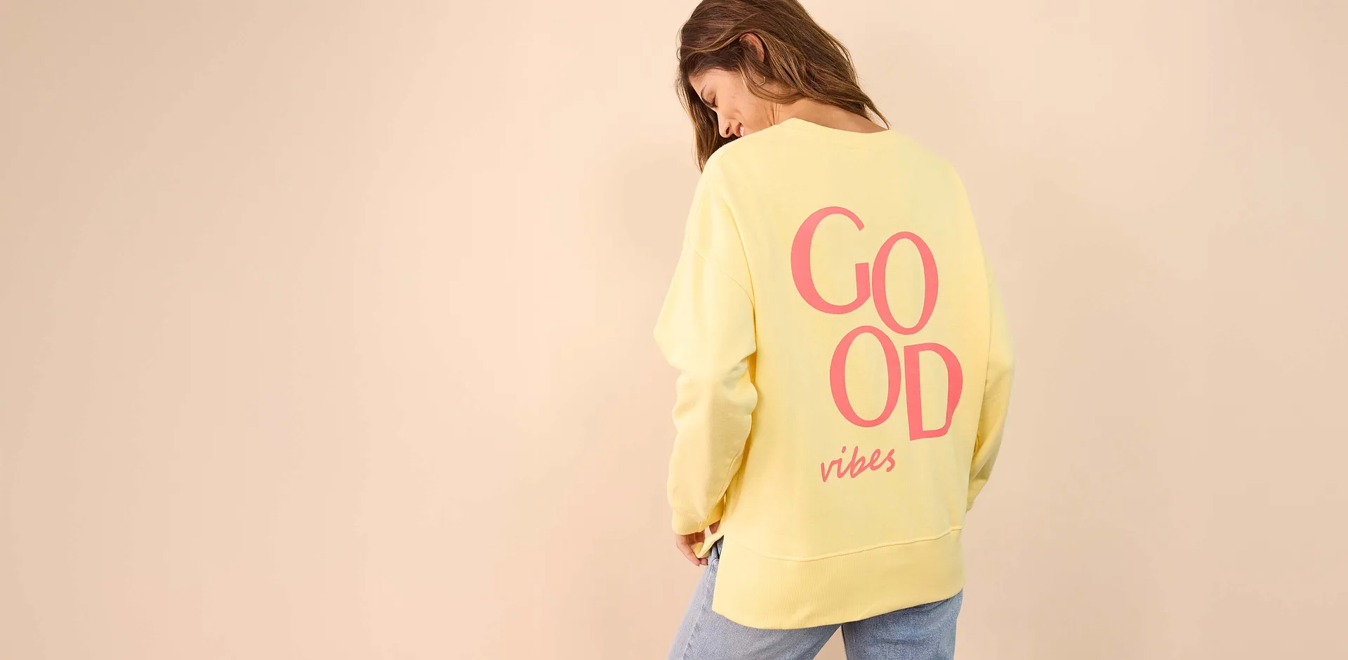 Felpa oversize gialla con stampa rosa &ldquo;Good vibes&rdquo; sul retro.