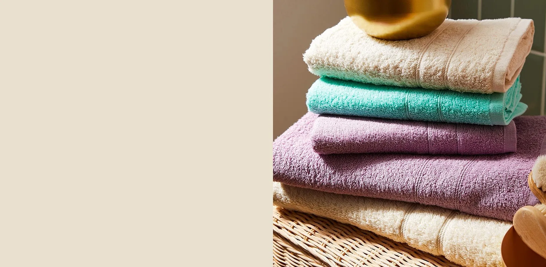 Asciugamani morbidi e colorati nei toni del crema, del menta e del viola, impilati con cura.