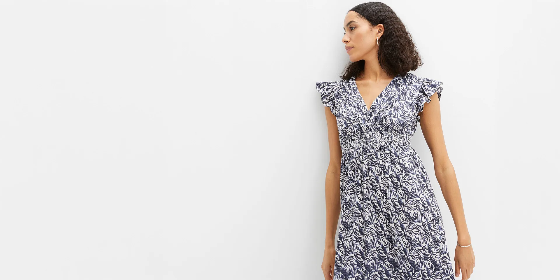 Elegante abito estivo con motivo a foglie blu, scollo a V e vita arricciata.