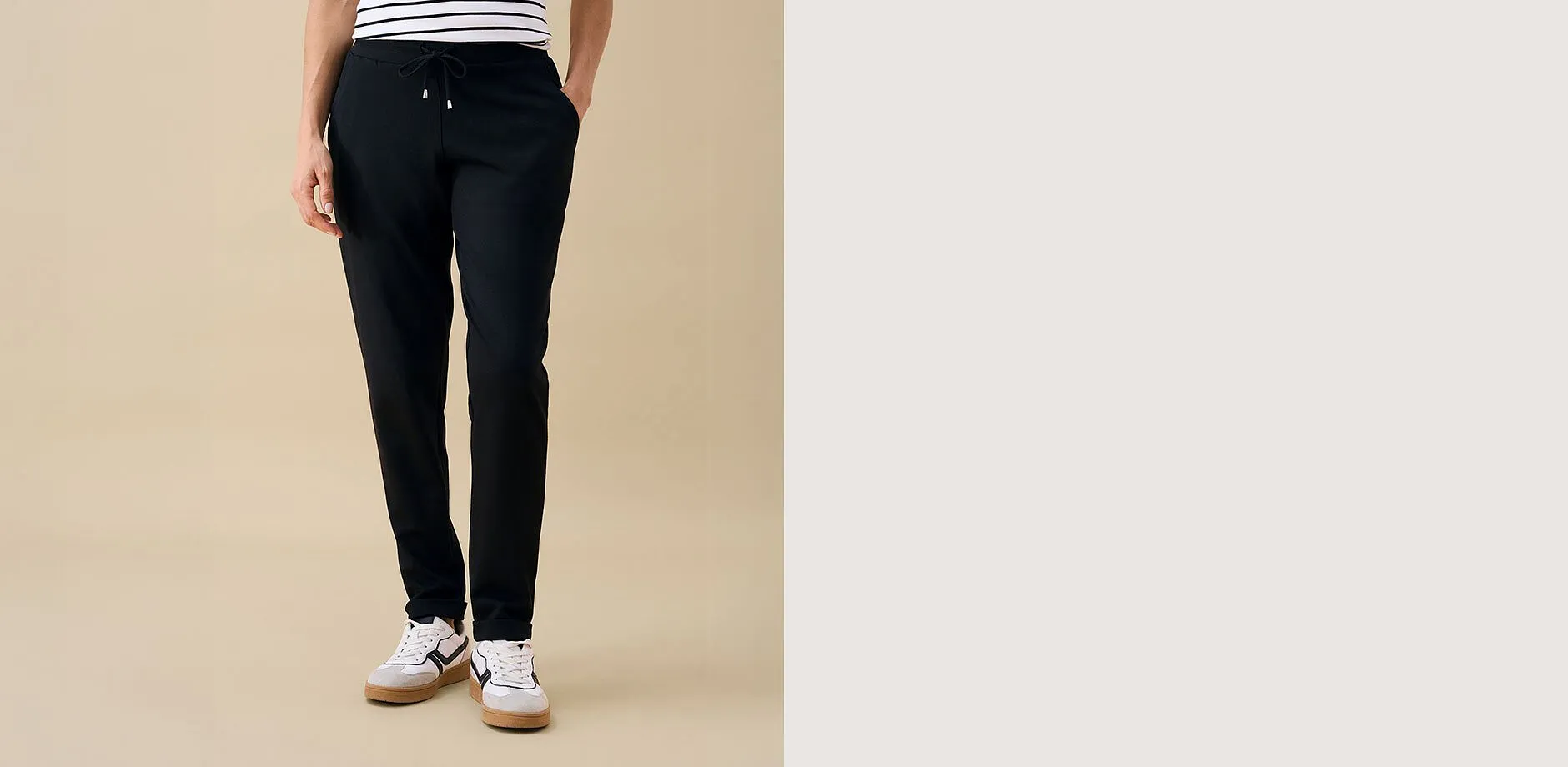 Pantaloni neri, maglietta a righe e sneakers alla moda: un look casual e comodo.