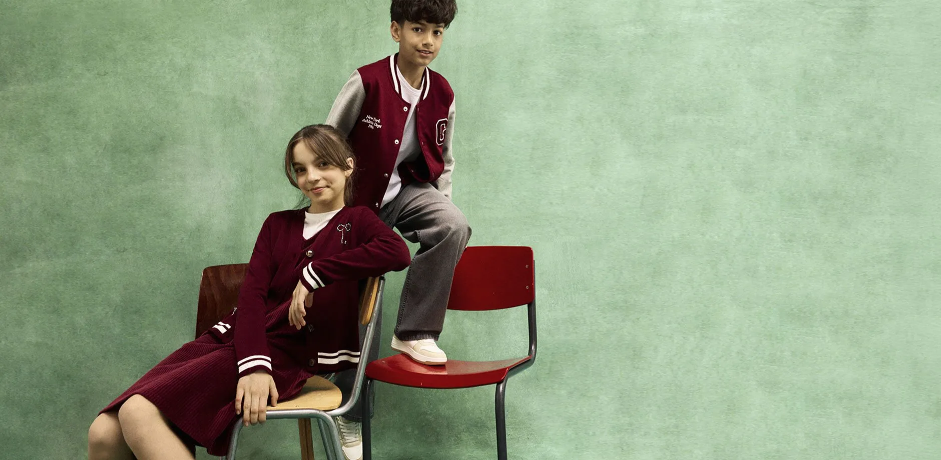 Bambino e bambina con giacca varsity.