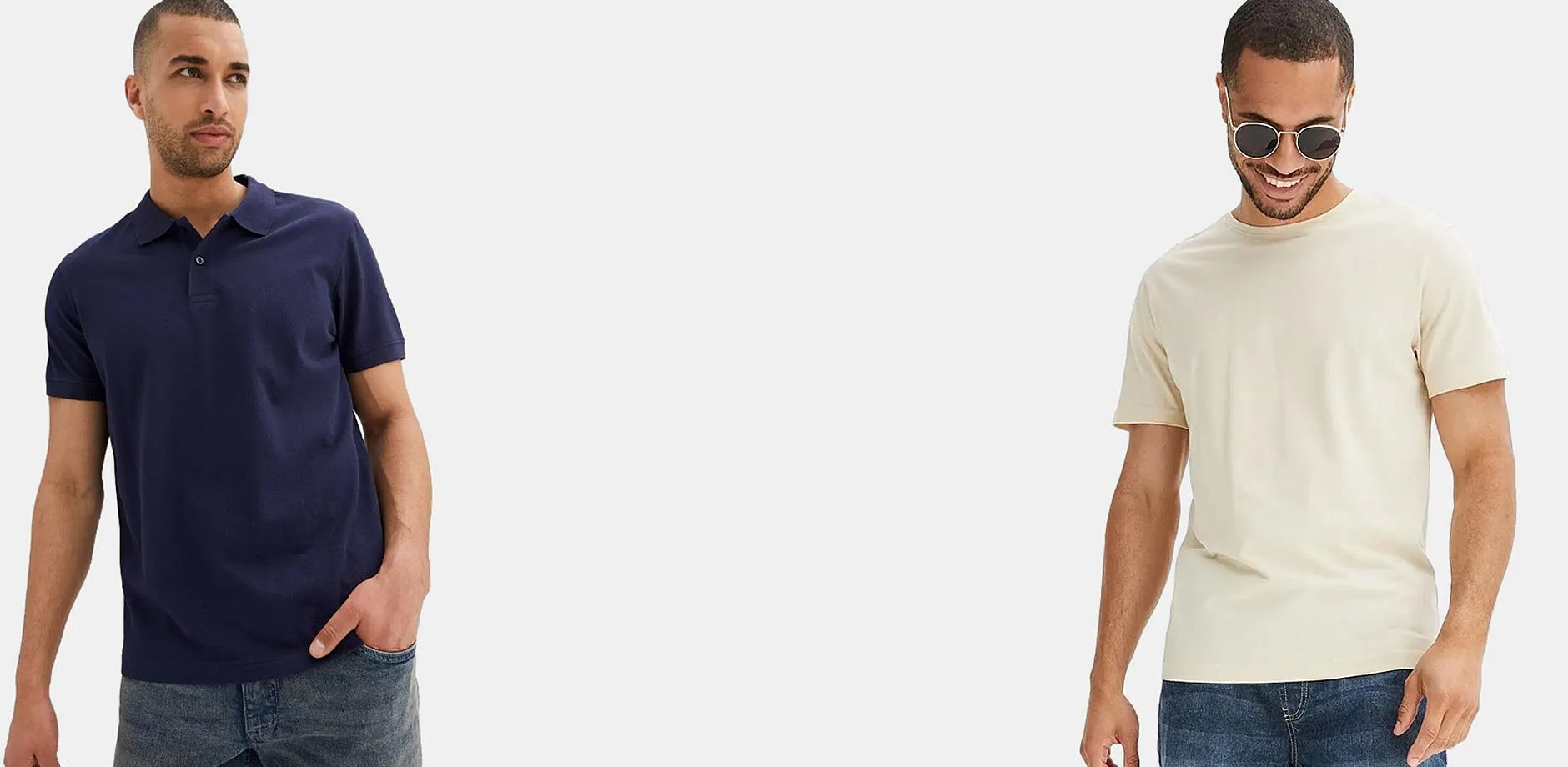 L'uomo a sinistra indossa una polo blu, mentre quello a destra indossa una semplice maglietta beige e dei classici jeans blu.