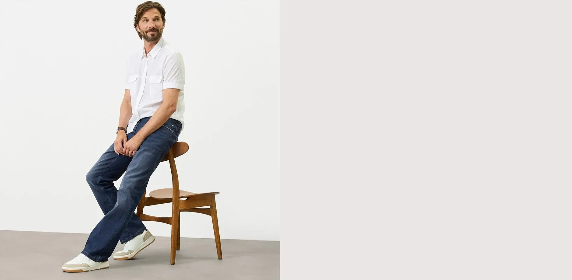Maglietta bianca, jeans blu regular fit e scarpe da ginnastica bianche.