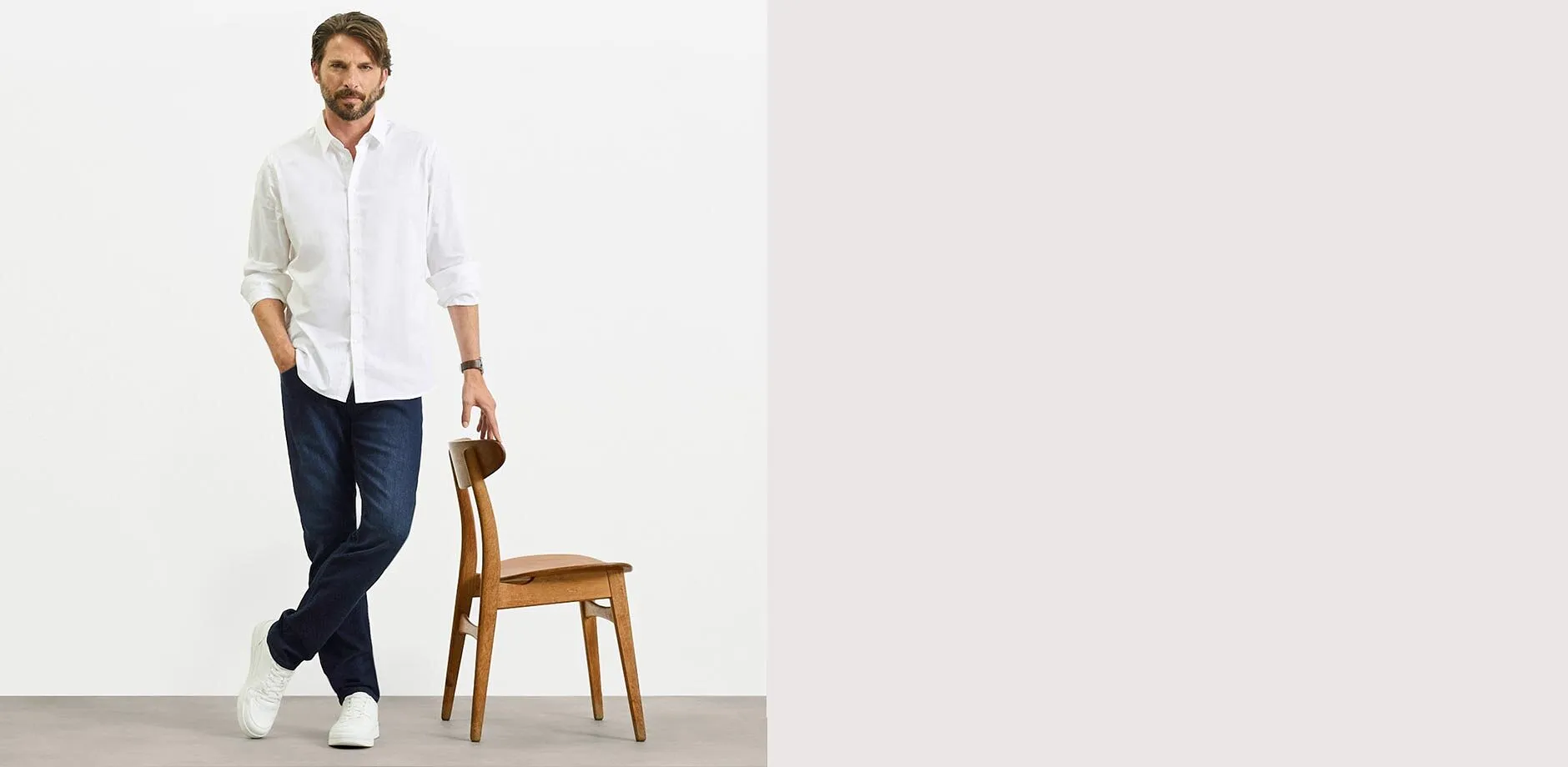Maglietta bianca, jeans slim fit blu e scarpe da ginnastica bianche.
