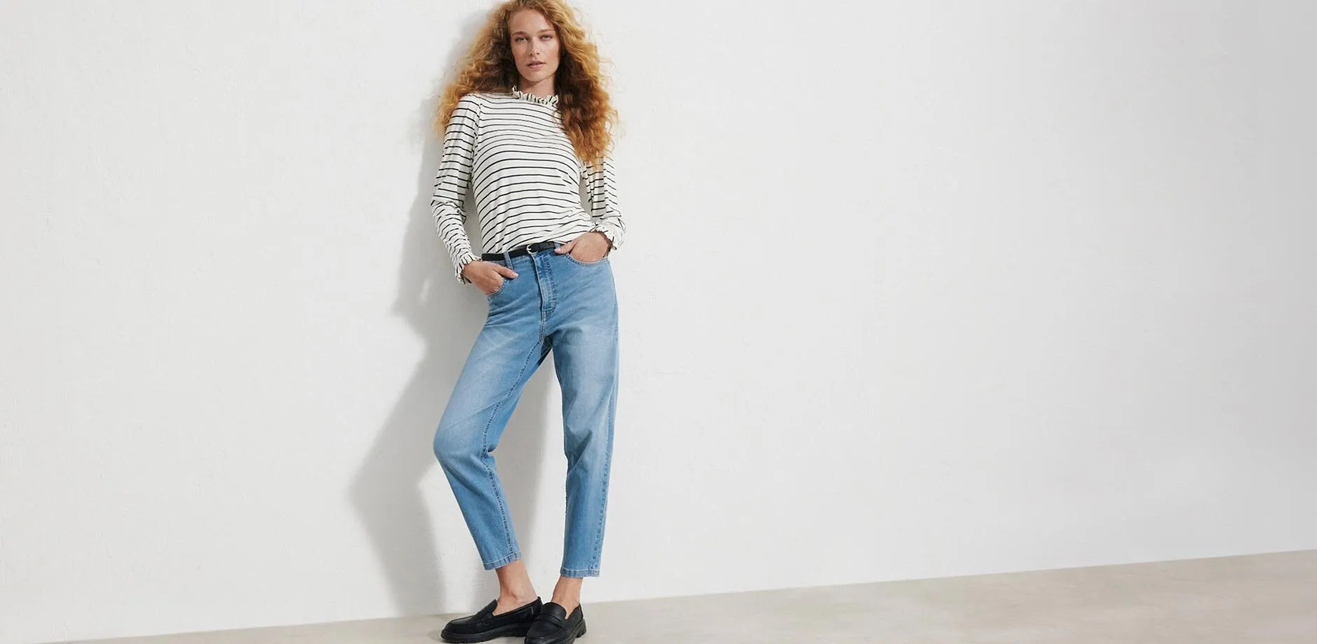 Maglia a righe a maniche lunghe, jeans chiari, cintura nera e comodi mocassini.