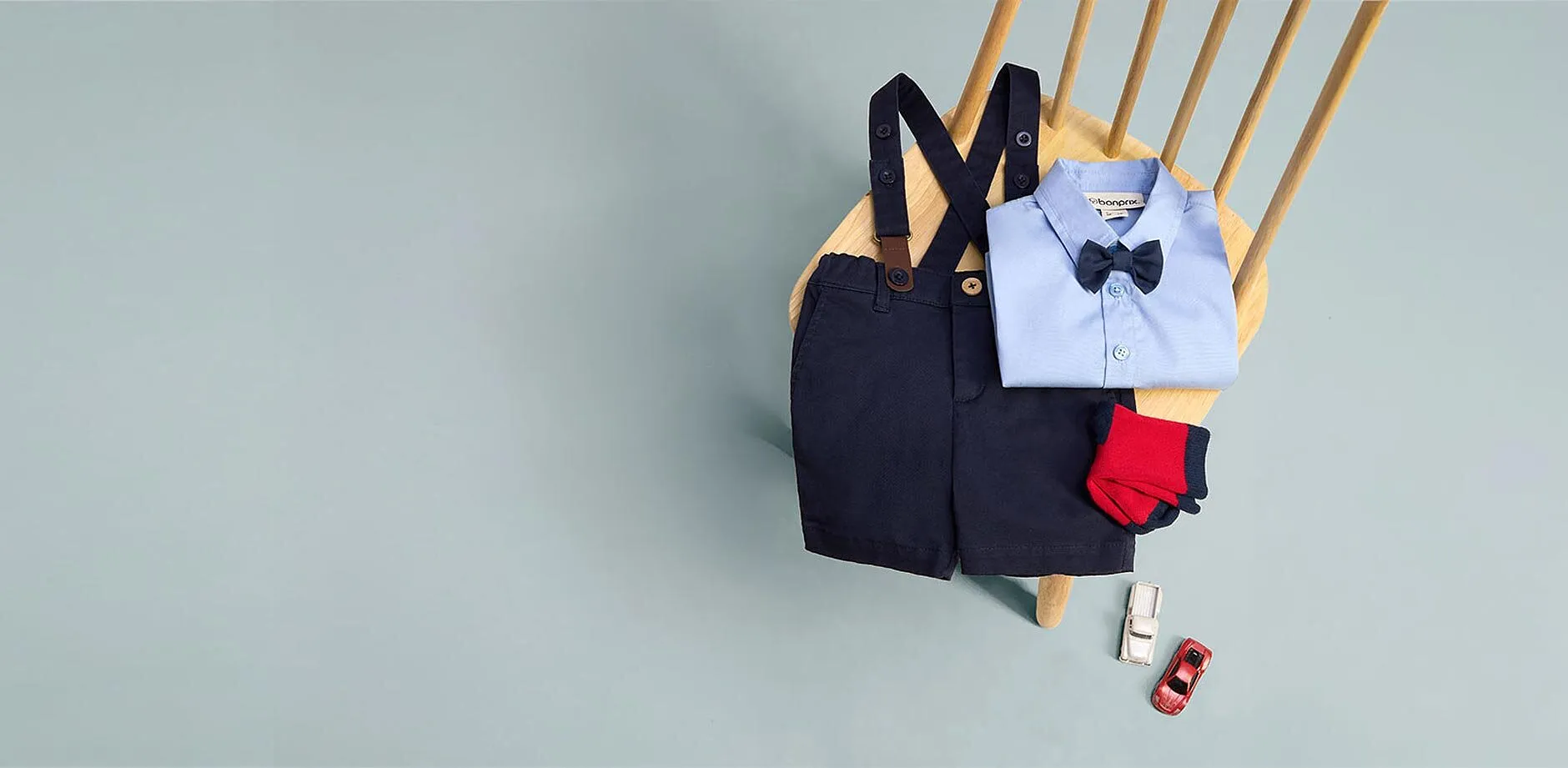 Salopette blu, camicia azzurra, papillon, calzini e scarpe rosse.