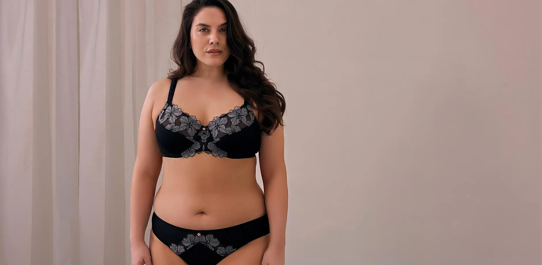 Elegante completo intimo nero con delicati ricami floreali, composto da reggiseno e slip.