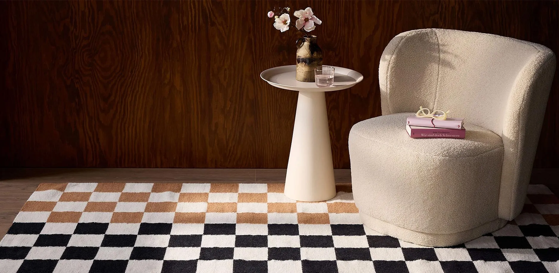 Una stanza elegante con tappeto a quadri, una comoda poltrona e un tavolino minimalista.