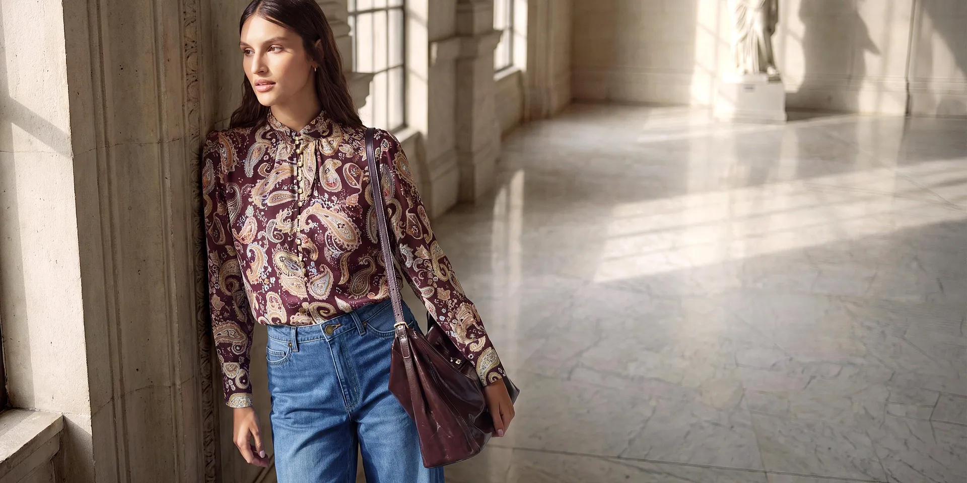 Look alla moda: camicetta con motivo Paisley, jeans larghi, scarpe eleganti e borsetta abbinata.