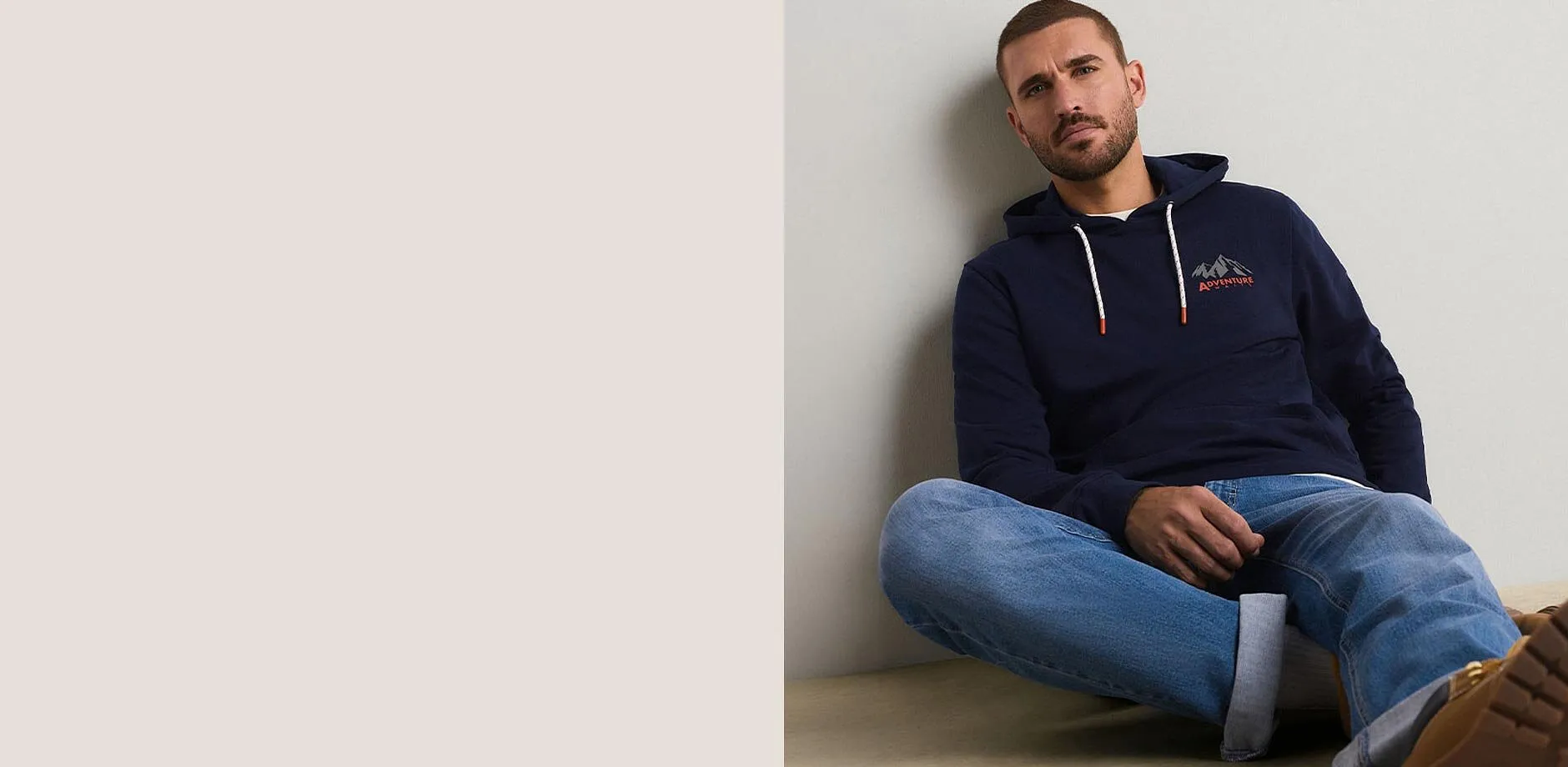 Felpa con cappuccio blu scuro con un motivo di montagna e un paio di jeans blu dal look casual.