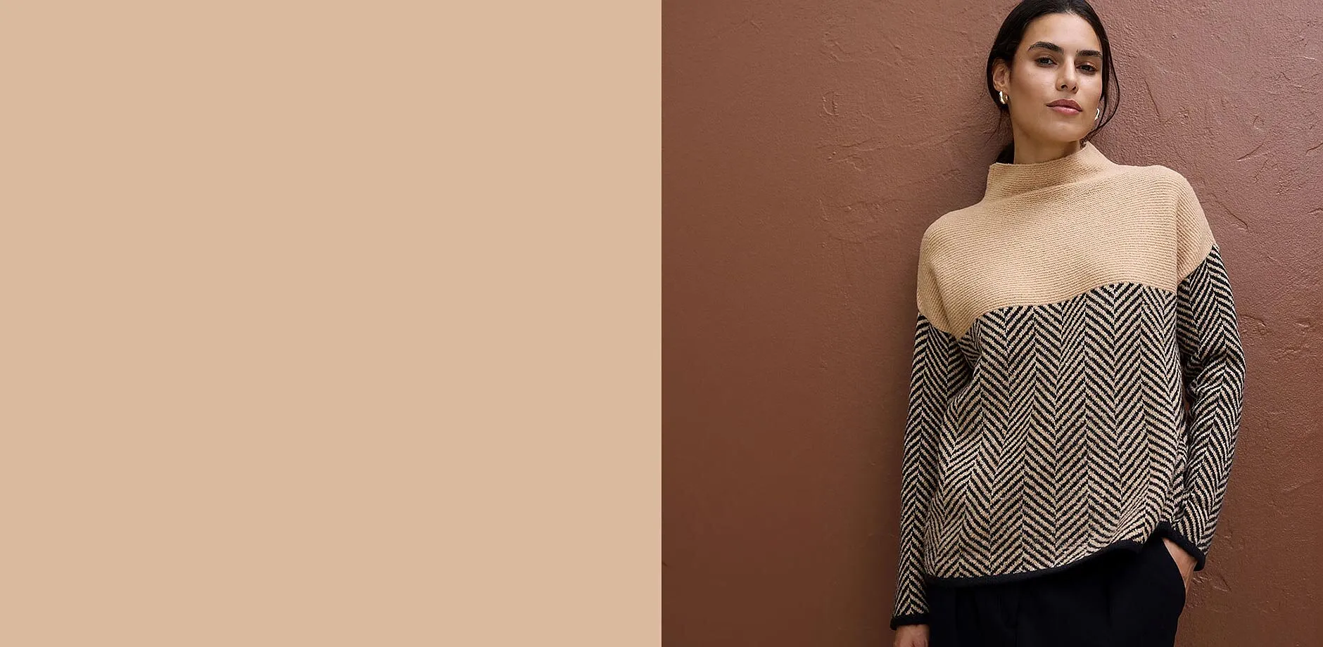 Maglione alla moda: collo alto beige, motivo a spina di pesce nero e beige.