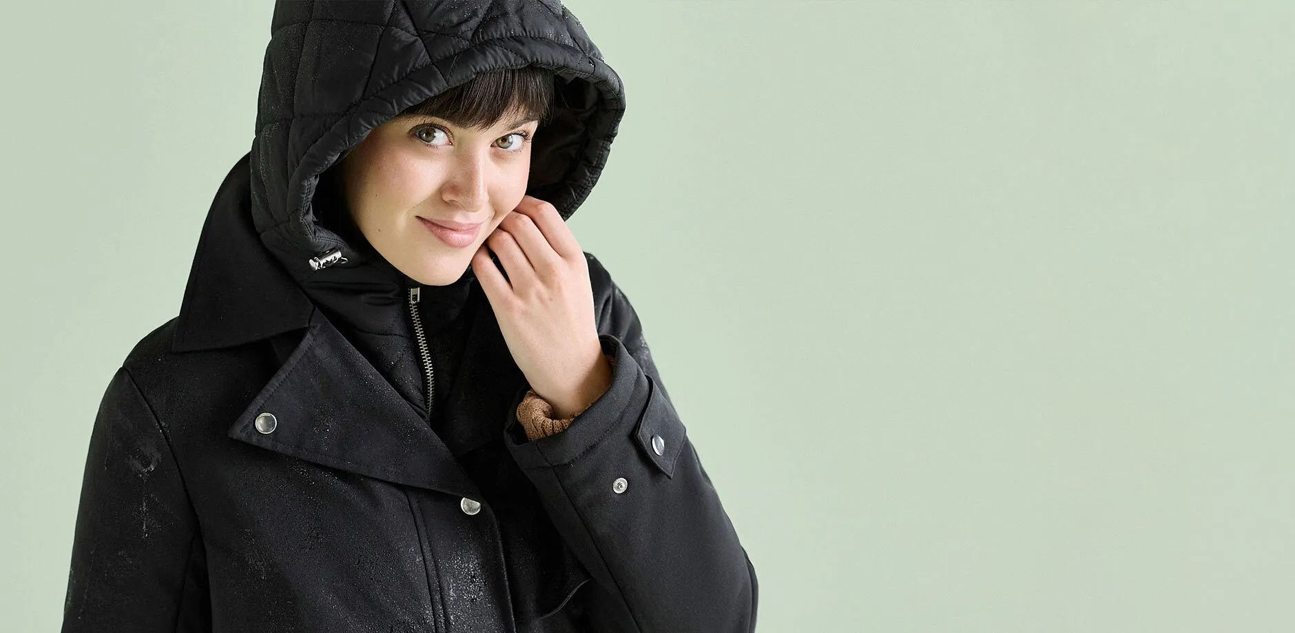 Elegante giacca doppia nera con cappuccio trapuntato, ideale per le giornate piovose.