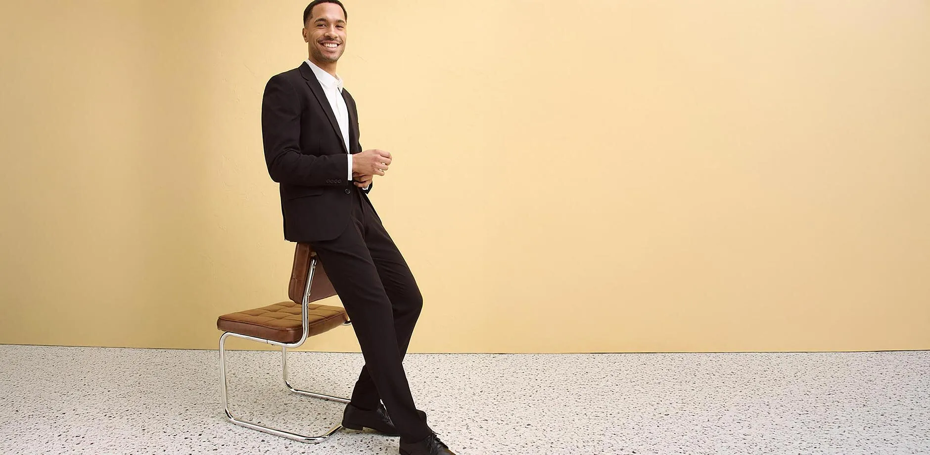 Elegante abito nero con camicia bianca, perfettamente abbinato alle scarpe coordinate.