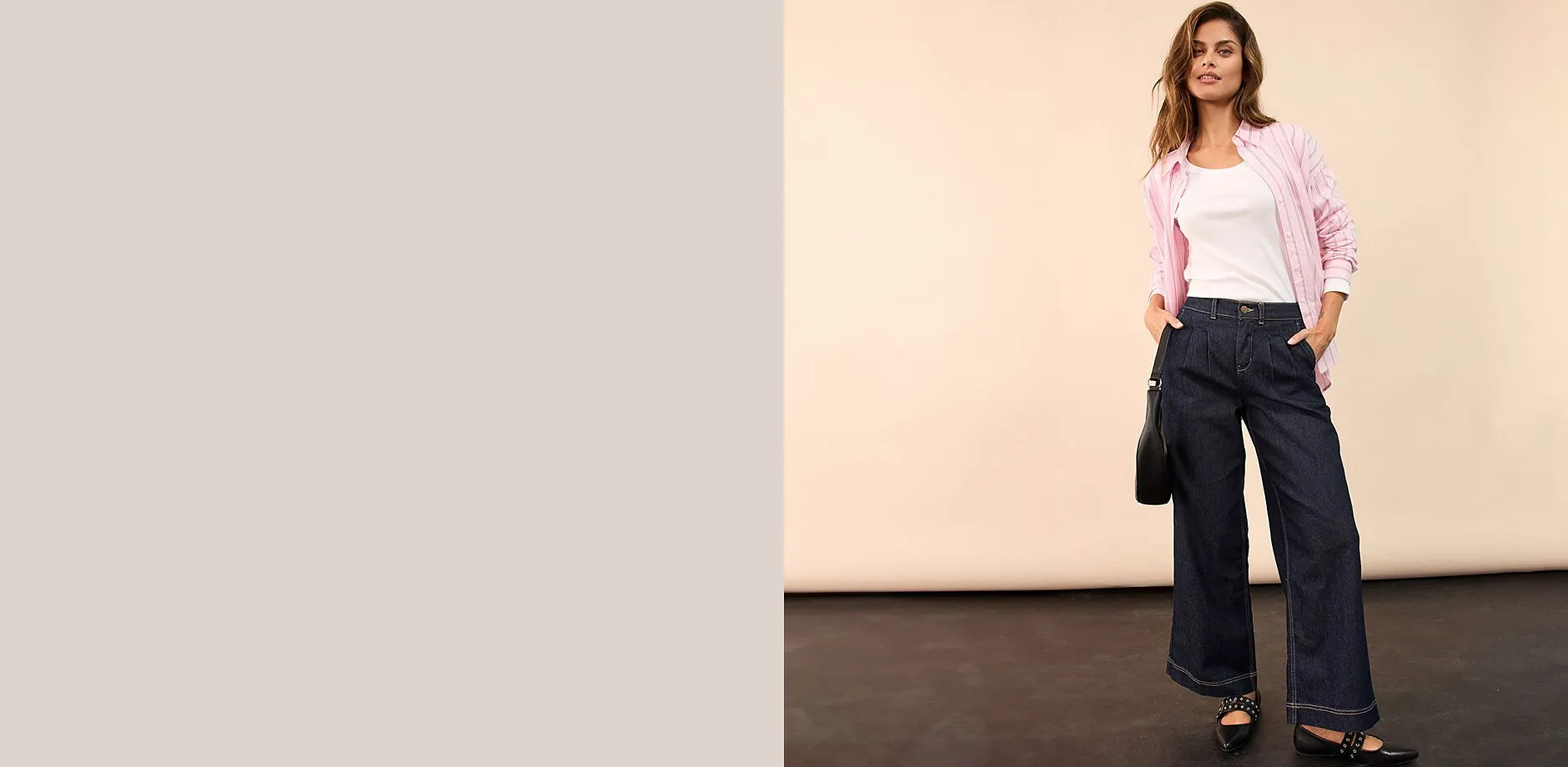 Camicetta rosa sopra una maglietta bianca, abbinata a jeans blu scuro.