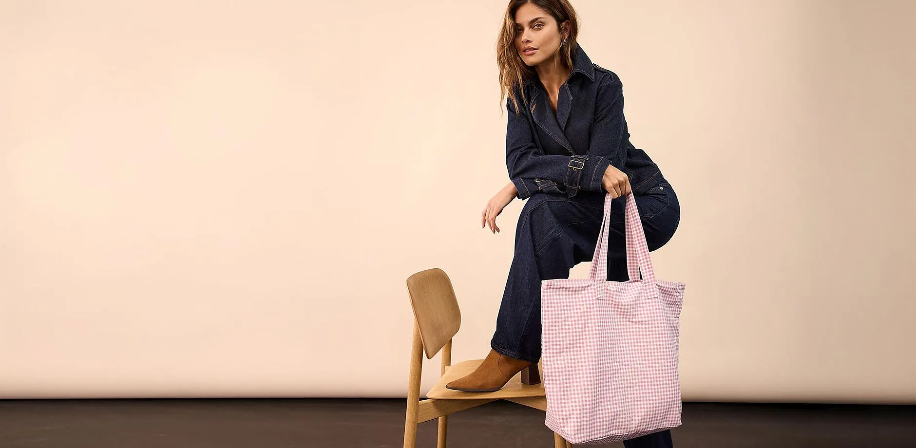 Outfit in jeans, abbinato a scarpe marroni e borsa rosa a quadri.