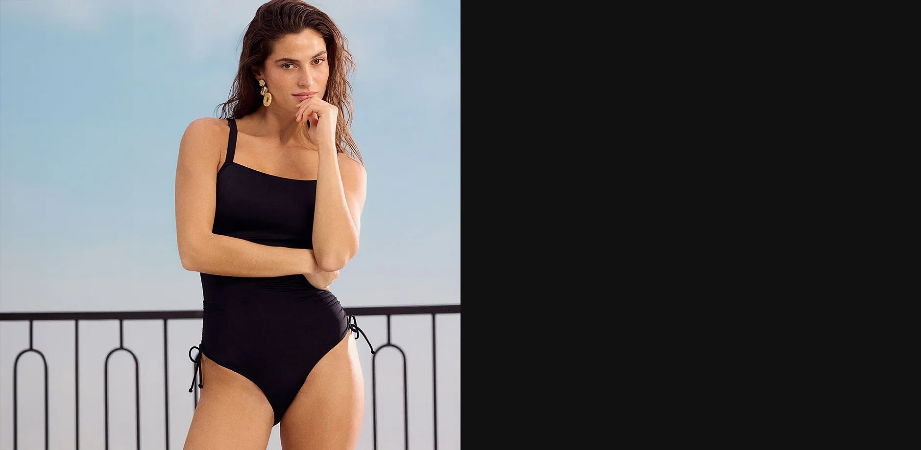 Elegante costume da bagno nero con spalline sottili, perfetto per una giornata al mare.