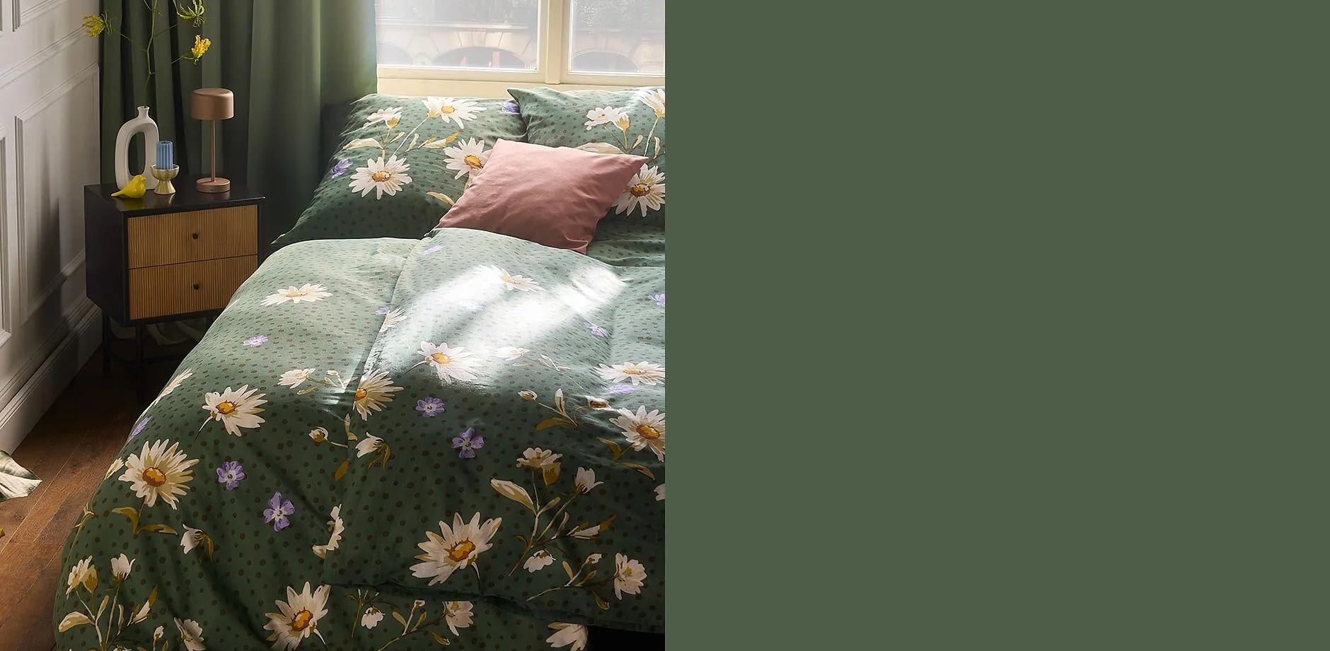 Lenzuola floreali verdi adornano il letto, completate da cuscini coordinati.