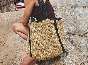 Borsa estiva in paglia con accenti neri.