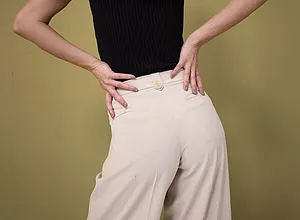 Elegante contrasto: un top nero senza maniche abbinato a pantaloni ampi color crema a vita alta.