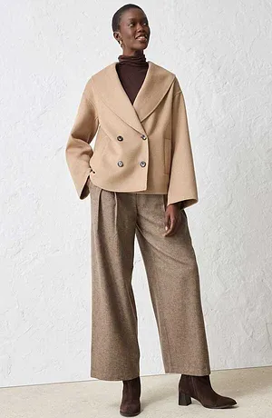 Giacca corta in misto lana beige, dolcevita marrone e pantaloni con pinces larghi.