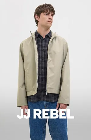 Camicia a quadri abbinata a giacca beige e blue jeans.