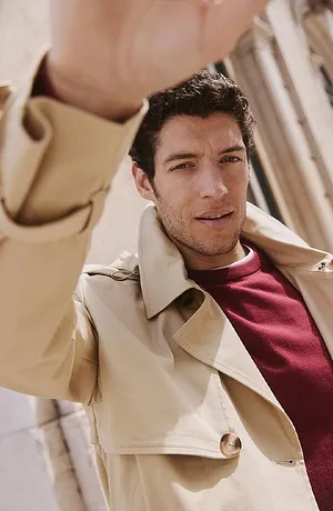 Trench beige elegante abbinato a pullover borgogna.