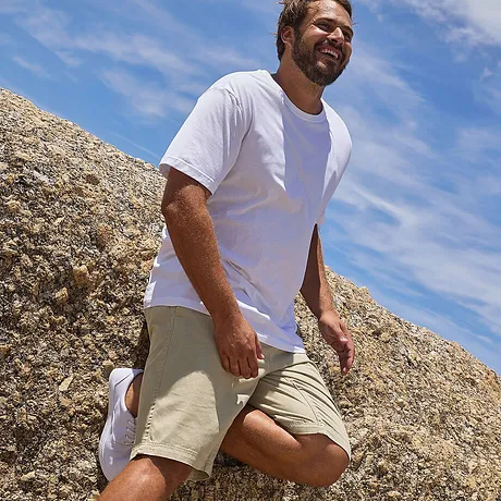 T-shirt bianca semplice e pantaloncini beige al ginocchio - perfetti per andare al mare.