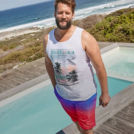 Canotta bianca con motivo tropicale, vivaci pantaloncini da bagno rossi e blu.