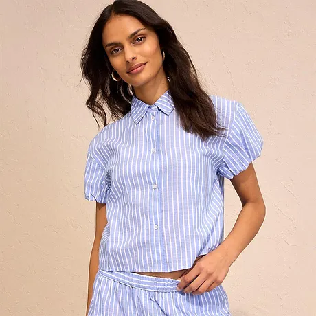 Camicia azzurra a righe con maniche corte a sbuffo e bottoni. Perfetta per un outfit estivo.
