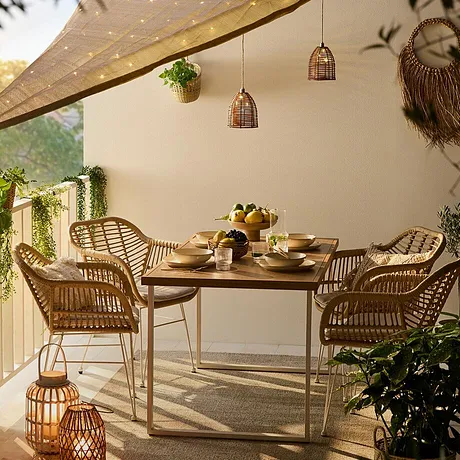 Terrazza accogliente con mobili in rattan, lampade romantiche e una tenda luminosa per serate suggestive. 