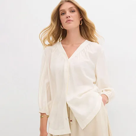 Elegante camicetta color crema con scollo a V e maniche ampie. 