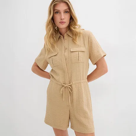 Jumpsuit beige a maniche corte con colletto a camicia, cintura e tasche sul petto. 