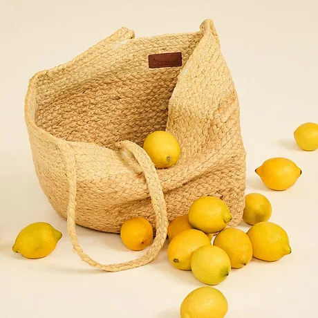 Borsa in paglia piena di limoni freschi.