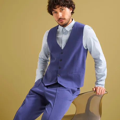 Completo blu elegante con gilet e camicia azzurra.