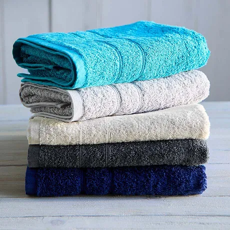 Una pila di morbidi asciugamani in vari colori: turchese, bianco, beige, grigio scuro e blu navy.