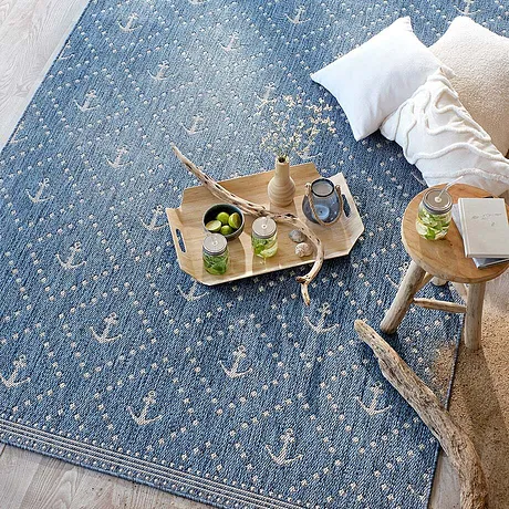 Un accogliente tappeto blu con dettagli bianchi invita al relax.