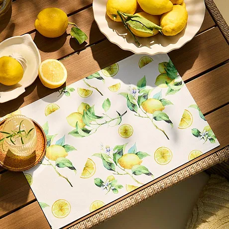 Un fresco motivo a limoni adorna la tovaglia, in pendant con i frutti gialli sopra.